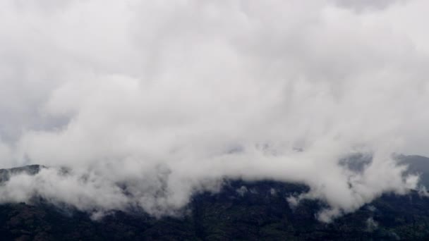 Хронология группы больших белых облаков, покрывающих горный пик — стоковое видео