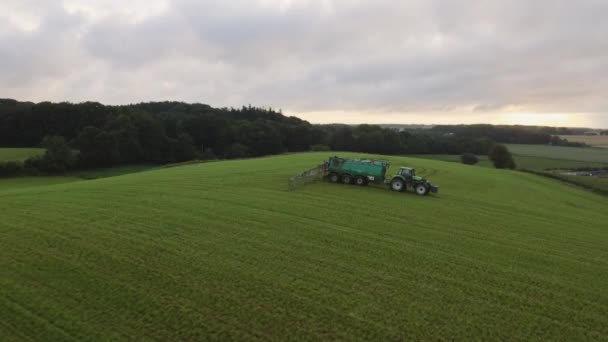 Saftig grüne Wiesen mit einem LKW in der Mitte, der das Feld für den Ackerbau anbaut — Stockvideo