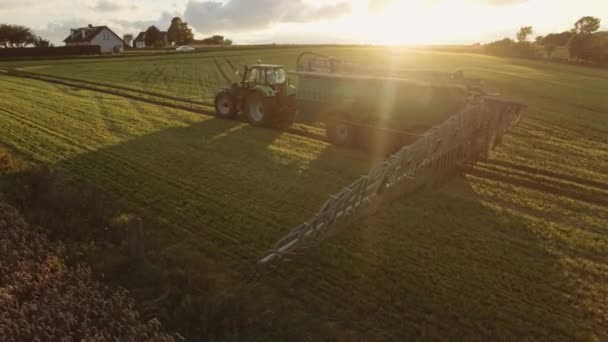 Tractor de agricultura va hacia atrás en un vasto campo de cultivos de plantación — Vídeo de stock