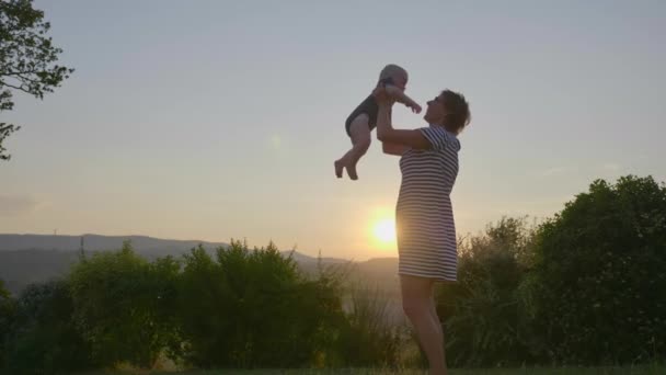 Breed schot van vrolijke moeder spelen met zijn schattige baby jongen en vervolgens knuffelen hem — Stockvideo