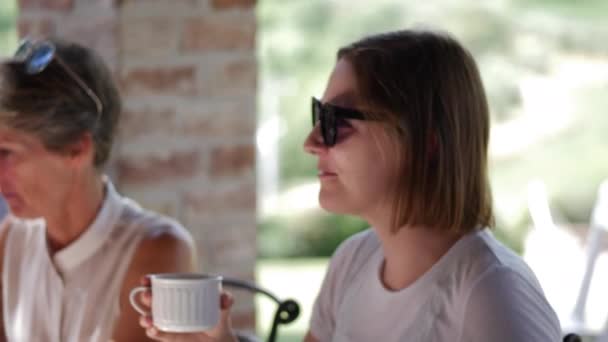 Женщина пьет из кружки во время семейного завтрака, Тоскана — стоковое видео