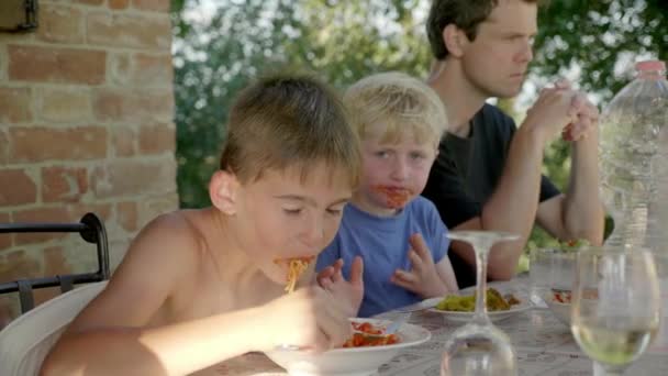 Un enfant qui mange joyeusement des spaghettis en famille — Video