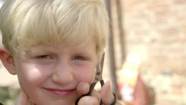 Porträt eines kleinen Jungen, dem die Haare geschnitten werden — Stockvideo