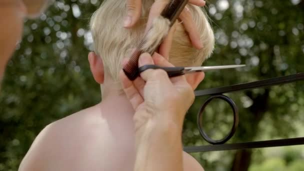 A Young Boy Having His Hair Cut Outdoors — Stok video