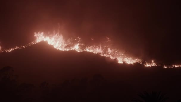 Blick von oben auf orangefarbene Flammen, die die Löwenkopfberge verbrennen — Stockvideo