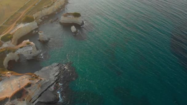Légi fókuszált lövés mély zöld vizek szélén a szikla — Stock videók