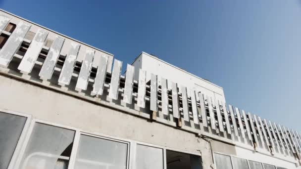 Старое промышленное здание с разбитыми окнами и голубым небом — стоковое видео