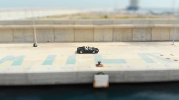 Black Ferrari Coasting by the Docks at Day