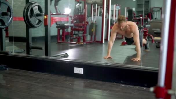 Muž dělá perfektní skok tlačit nahoru, zatímco to dělá před obrovským zrcadlem — Stock video