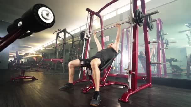 Piloto barbudo haciendo ejercicio de la prensa del pecho de la barra en un gimnasio — Vídeos de Stock