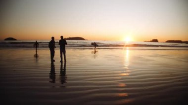 Turistler ve Sörfçüler Denizde Gün Batımını İzliyor