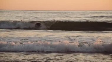 Yavaş Hareket Denizi 'nde Günbatımı Sörfçüleri