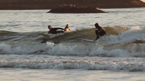 El hombre surfeando en el mar de cámara lenta al atardecer — Vídeos de Stock