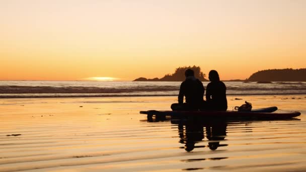 Silhouet jongens chatten op surfplanken bij zonsondergang — Stockvideo