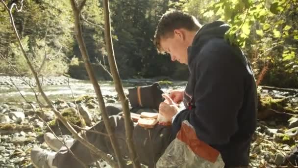 Homme faisant des sandwichs près de la rivière — Video