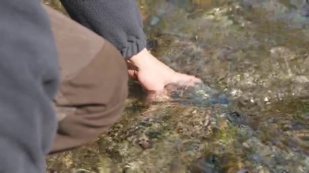 Чоловік наповнює пляшку води в річці — стокове відео