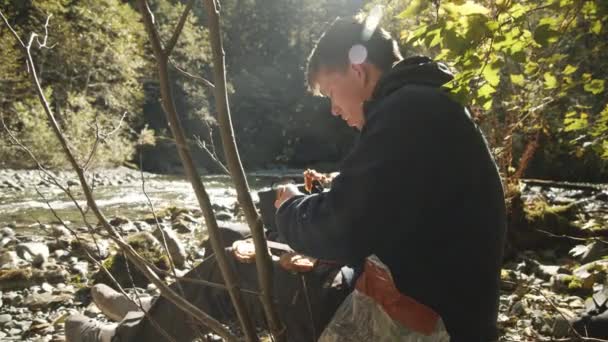 Hombre haciendo sándwiches por río — Vídeo de stock