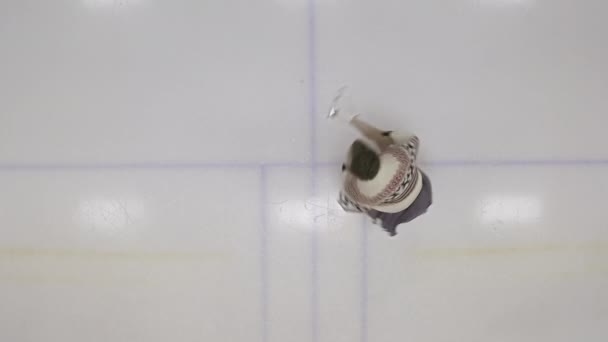 Patineur sur glace qui tourne en vue de tirer sur la patinoire — Video