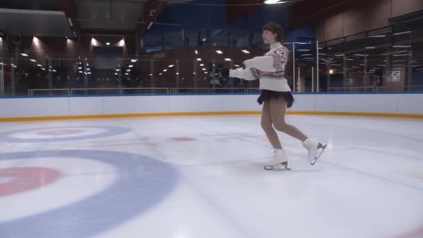 Łyżwiarka w swetrze występująca na lodowisku — Wideo stockowe