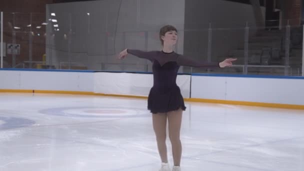 Chica adolescente patinaje sobre hielo en pista de patinaje — Vídeos de Stock