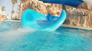 Küçük kız kayıyor ve sonra suya atlıyor.