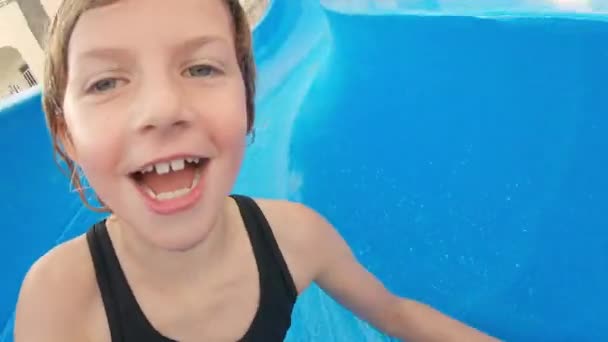 Câmera de mão Filmagem de uma menina deslizando para baixo da piscina — Vídeo de Stock