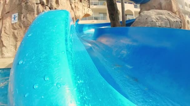 Tracking Shot of a Fun-loving Girl Going Down the Slide and into the Water — Stock video