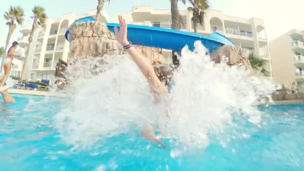 Under vattnet avslöjar skott av en ung flicka glider ner poolen — Stockvideo