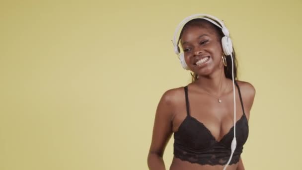 Joven chica negra bailando para teléfonos inteligentes y auriculares — Vídeo de stock