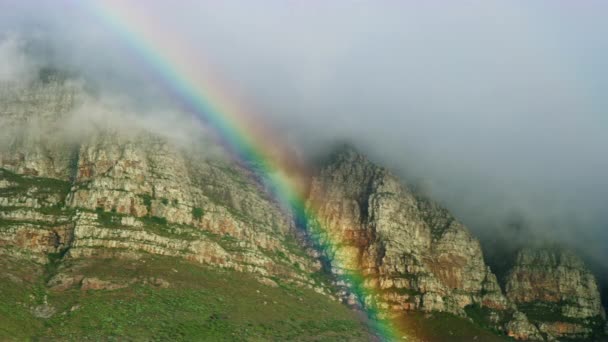 Arco iris y nubes sobre el paisaje de montaña — Vídeo de stock
