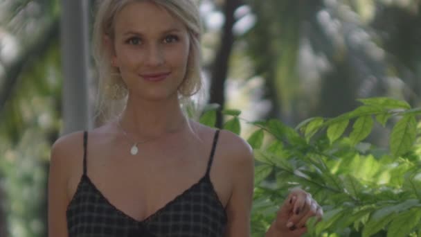 Jeune femme blonde souriante dans le jardin ensoleillé — Video