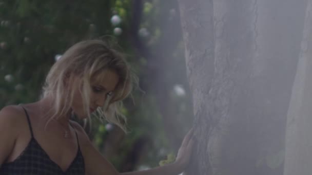 Vacker blond kvinna går runt träd — Stockvideo