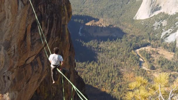 Shot of Man 's Back Sentado en las cuerdas flojas con una impresionante vista del valle — Vídeo de stock