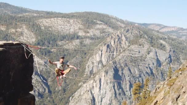 Fearless Man Standing Up Then Slips on the Slacklining Rope — Stock video