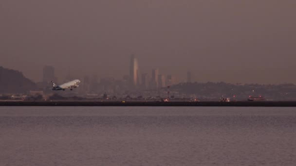 Avión despegando con la vista de los edificios de la ciudad en segundo plano — Vídeo de stock