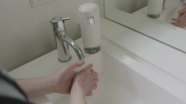 Girl Using Hand-Pump Sanitizer In Bathroom