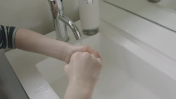 Мальчик с помощью дезинфицирующего средства в ванной раковине — стоковое видео