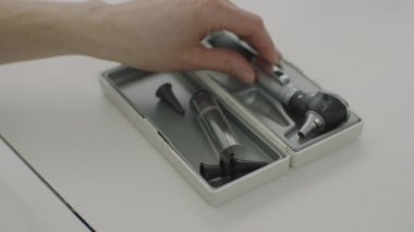 Otoskop 'u hastaların kulaklarına bakmak için hazırlayan doktorun el kamerasını kapat.