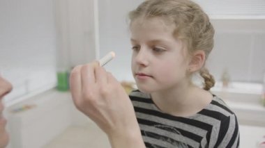 Dr. Shine 'ın gözlerine ışık tutarak Coronavirus (Corvid19) testine tabi tutulan genç bir kızın el kamerası görüntüsü.