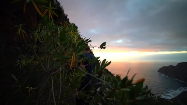Человек, идущий узким путем, прошел кактусы на склоне горы — стоковое видео