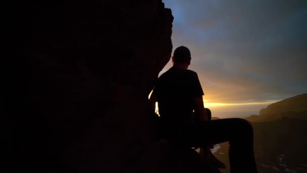 Людина дивиться на схід сонця з гір — стокове відео