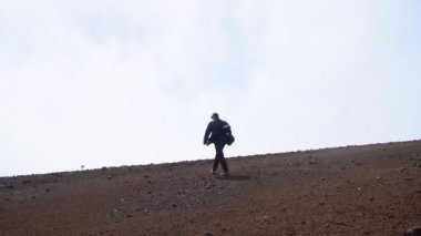 Taşlı Topraklarda Bulutlara Doğru Yürüyen Adam