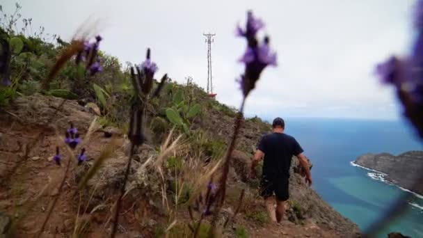 Hombre caminando en la ladera de la montaña — Vídeos de Stock