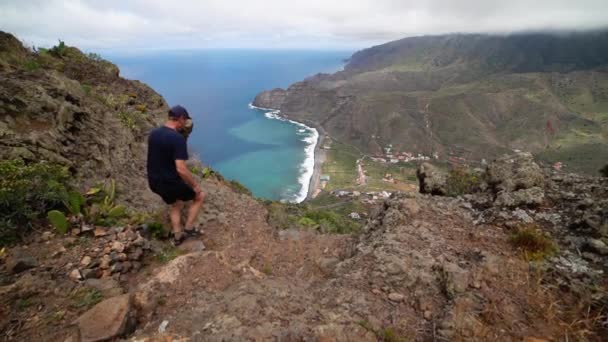 Uomo che cammina sul fianco della montagna — Video Stock