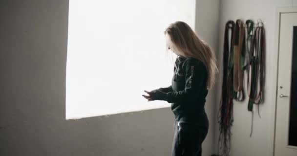 Красивая молодая женщина снимает куртку в спортзале — стоковое видео