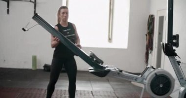 Spor salonunda kürek çeken bayan sporcu.
