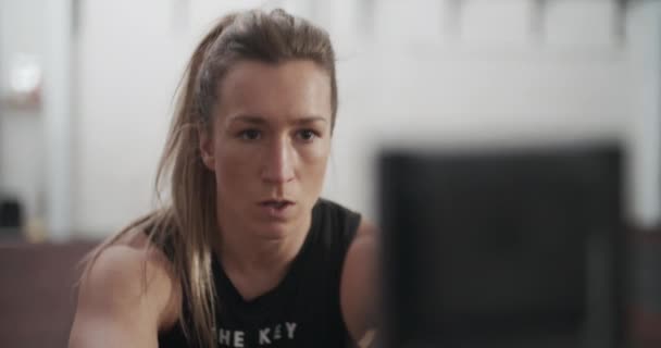 Atleta femenina mirando el entrenamiento en la máquina de remo — Vídeos de Stock