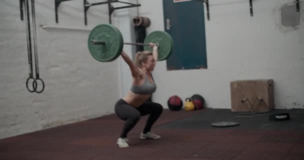 Kvinnlig idrottare som lyfter tung skivstång — Stockvideo