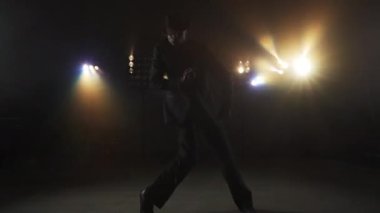 Siyah Giysili Adam Yanıp sönen ışıkların önünde dans ediyor