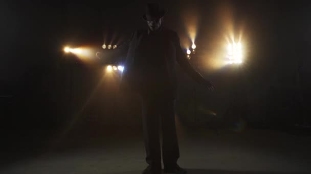 Uomo in abito nero che balla davanti a luci lampeggianti — Video Stock
